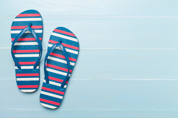 Bright flip flops on wooden background, top view