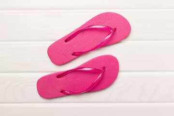 Bright flip flops on wooden background, top view