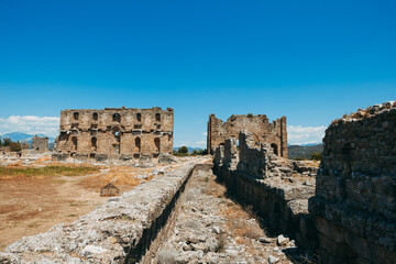 Aspendos archaeological site featuring the well-preserved amphitheater and arches, buildings in Side, Antalya, Turkey.