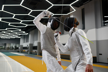 Two fencers crossed swords before fight, closeup shot of fencing dual start