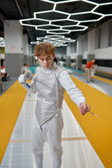 Portrait of confident teenage boy fencer with sharp sword