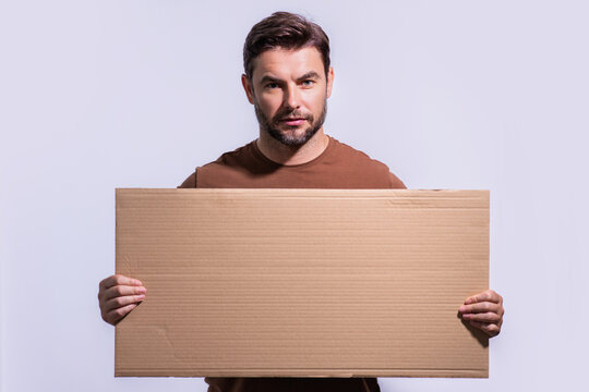 Man with empty blank board on studio background. Blank signboard with copy space. Advertisement concept. Ad board with copy space, blank mock up copy space. Blank signboard, placard with copy space.