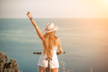 Naklejka premium Woman travel bike sea. Happy woman cyclist sitting on her bike, enjoying the beautiful mountain and sea landscape, signifying the idea of an adventurous bike ride.