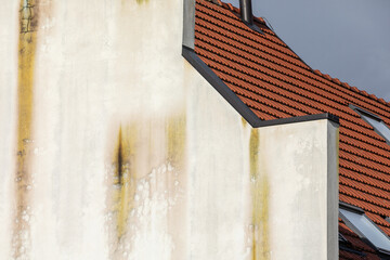 Building facade with water runoff damage. Roof