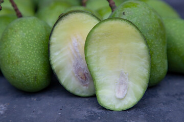 Closeup focus Fresh Raw  Mango with sliced mango on the concrete floor. Pickle ingredient