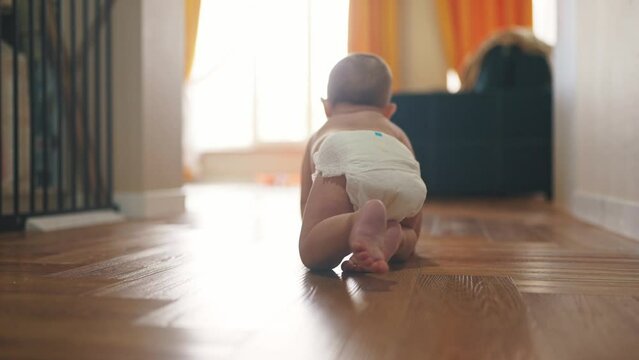 baby son crawling. happy family a first steps kid dream concept. baby newborn crawling down the hallway in the house. happy baby boy crawling on the floor takes her lifestyle first steps