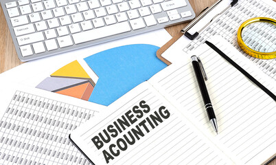 BUSINESS ACCOUNTING text on a paper on chart background