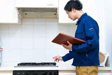 キッチンをチェックする日本人男性 - obrazy, fototapety, plakaty