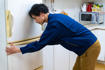 冷蔵庫を運ぶ日本人男性