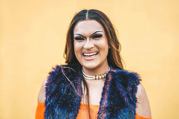 Happy drag queen smiling at camera on a yellow background - Trans man celebrating gay pride day -...
