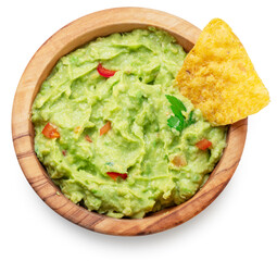 Guacamole bowl and corn chips dipped in it on white background. Top view. File contains clipping path.