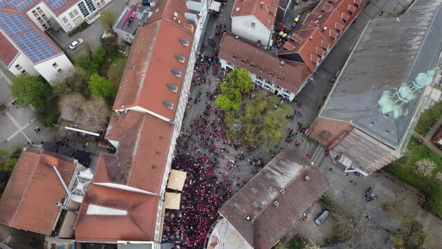 Birds Eye Aerial view : Bars of the Party Zone Square in old city Kaiserslautern fully crowded on Saturday night with FCK Kaiserslautern football Audience fans celebrating victory ( win ) with a beer