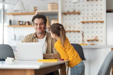Smiling man working online while his daughter using a red chopstick on him.