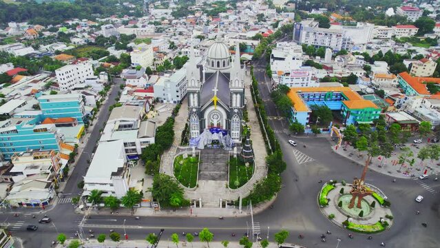 Aerial view of Thu Dau Mot cityscape at morning with church on hill in center. Urban development texture, transport infrastructure and green parks along Be River in Southeast region of Vietnam