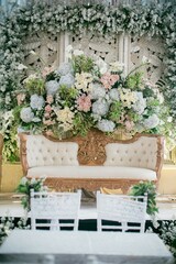 Fototapeta na wymiar A luxurious Indonesian-style wedding sofa, adorned with intricate carvings and intricate patterns, fit for a royal wedding. Its regal design exudes elegance and cultural richness