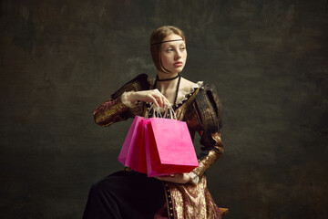 Portrait of pretty, young, elegant girl, royal person in vintage dress holding many shopping bags...