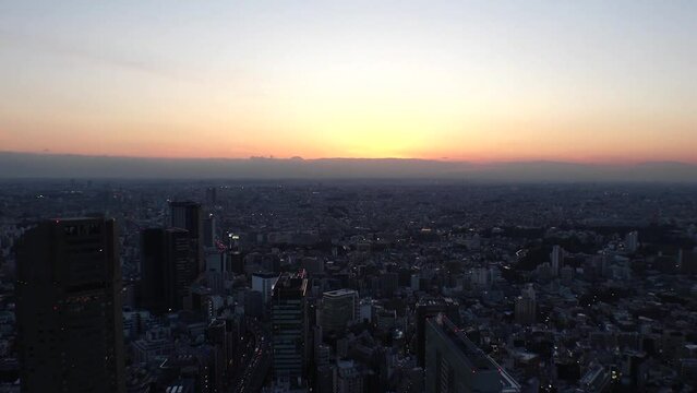 TOKYO, JAPAN : Aerial high angle sunrise CITYSCAPE of TOKYO. View of rising sun and dramatic sky around Shibuya. Japanese urban city life and nature concept video. Time lapse shot, night to morning.