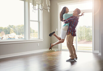 Happy couple, moving into their new home and hug for mortgage or property buy or together in empty...