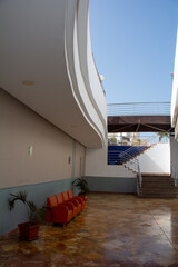 Armchairs under a balcony with stairs and sky