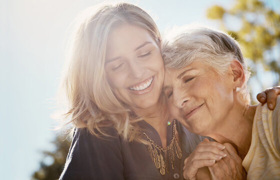 Family, love or smile with a senior mother and daughter bonding outdoor together during a summer day. Happy, flare and retirement with a young man hugging her elderly parent outside in the park
