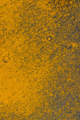 yellow ground turmeric sprinkled on a black slate board