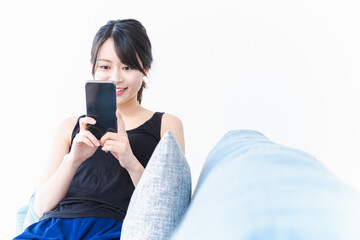 Fototapeta premium 下着を着てスマホを使う若い女性