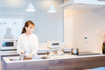 おうちのキッチンで料理をする主婦 © maroke