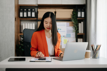 Business woman using tablet and laptop for doing math finance on an office desk, tax, report, accounting, statistics, and analytical research concept