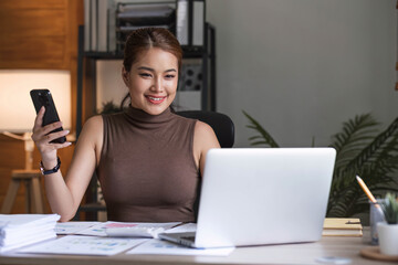 Young asian businesswoman beautiful charming smiling and talking on the mobile phone in the office.