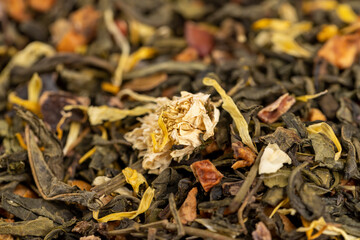 A large amount of dry green tea with pieces of fruit