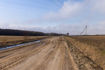 a broken country road at the beginning of spring