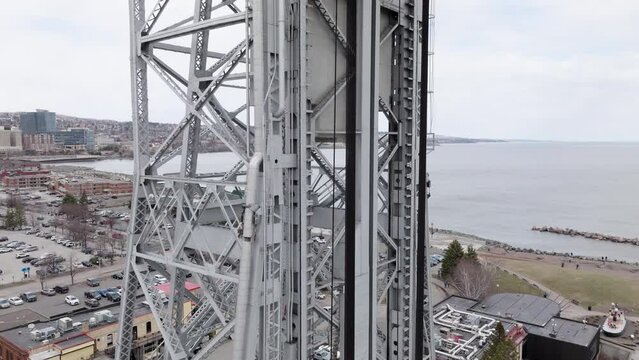 Steel towers and cables of aerial lift bridge in Duluth, Minnesota as cars drive across shipping canal 