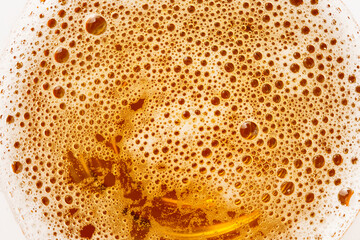 Beer foam and bubbles close-up in a glass, macro