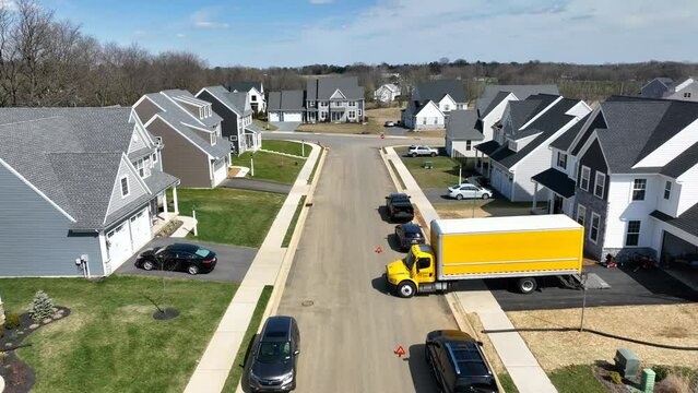 Neighborhood with large family homes. Aerial shot of newer houses and residential construction with moving relocation van truck.