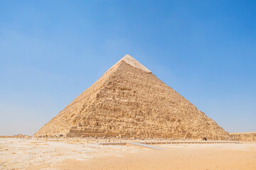 Fototapeta na wymiar high pyramid of Chephren on the background of a blue sky with clouds, Giza, Cairo, Egypt. second pyramid. Pyramid of Khafra on a cloudy day