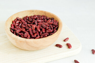 Raw red kidney beans in a wooden bowl. The concept of vegan food. The meal is enriched with protein. Ingredient for dietary dishes. Horizontal orientation. Selective focus. Copy space