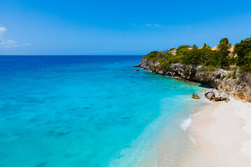 Fototapeta na wymiar Playa Kalki Beach Caribbean island of Curacao, Playa Kalki in Curacao, white beach with a blue turqouse colored ocean. Drone aerial view above a beach with beach chairs and umbrellas