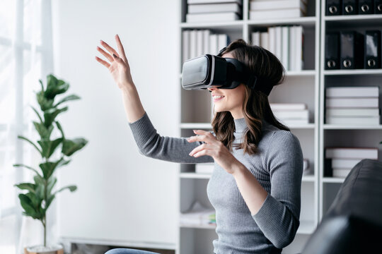 Businesswoman with vr headset lifestyle concept, Businesswoman wearing VR headset to playing game and touching in the air for experience virtual reality while relaxation with technology after working - Powered by Adobe