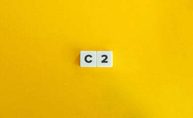 C2 level of language proficiency. Block Letter Tiles on Yellow Background. Minimal Aesthetics.