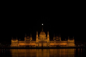 Parliament of Budapest at night with the moon above.