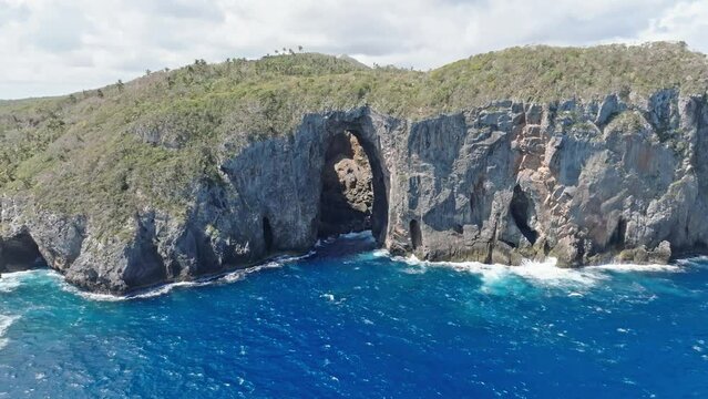 Drone shot in front of El Arco Las tres Puertas grotto, in Cabo Cabron, Dominican republic