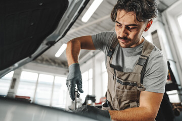 Fototapeta na wymiar Mechanic examining car in auto car repair service center