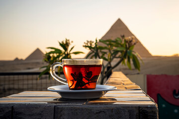 glass mug with tea on beautiful background of the main attractions of Egypt, the Great pyramids of Giza. - obrazy, fototapety, plakaty