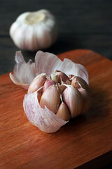 closeup of raw garlic on a wooden plate