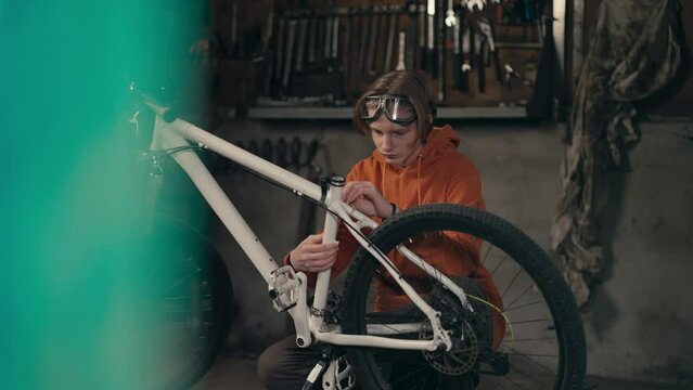 Serious Dedication: Teenager's Passion for Bike Maintenance and Repair in the Workshop