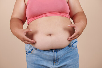 she wants to lose weight concept of abdominal fat surgery., the girl takes extra fat on sides of her stomach with her hand. isolate on white background, Type with increased fat deposition and fullness