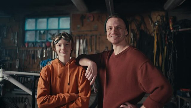 Industrial Mastery: A Teen and Mechanic's Dedication. Master and his young assistant posing against the backdrop of the workshop