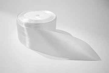 Roll of white textile ribbon. Mockup of roll from satin fabric tape on white background