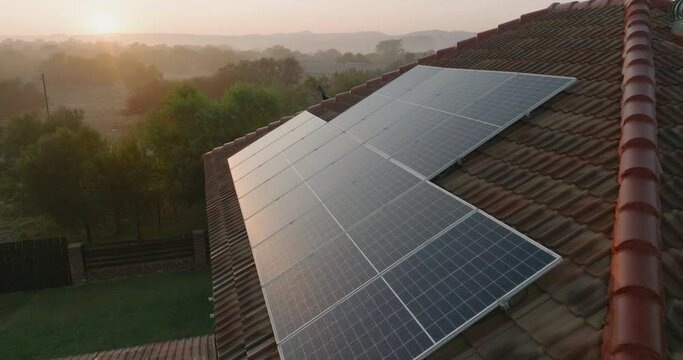 Aerial view of sunlight catching the photovoltaic solar panels on a suburban house rooftop. Climate change,Global warming