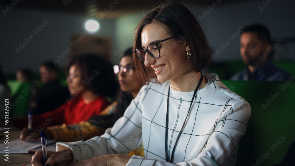 Poster Portrait of a Happy Smart Female Student, Studying in University with Diverse Multicultural Colleagues. She is Writing Down a Summary from the Lecture in Her Notebook